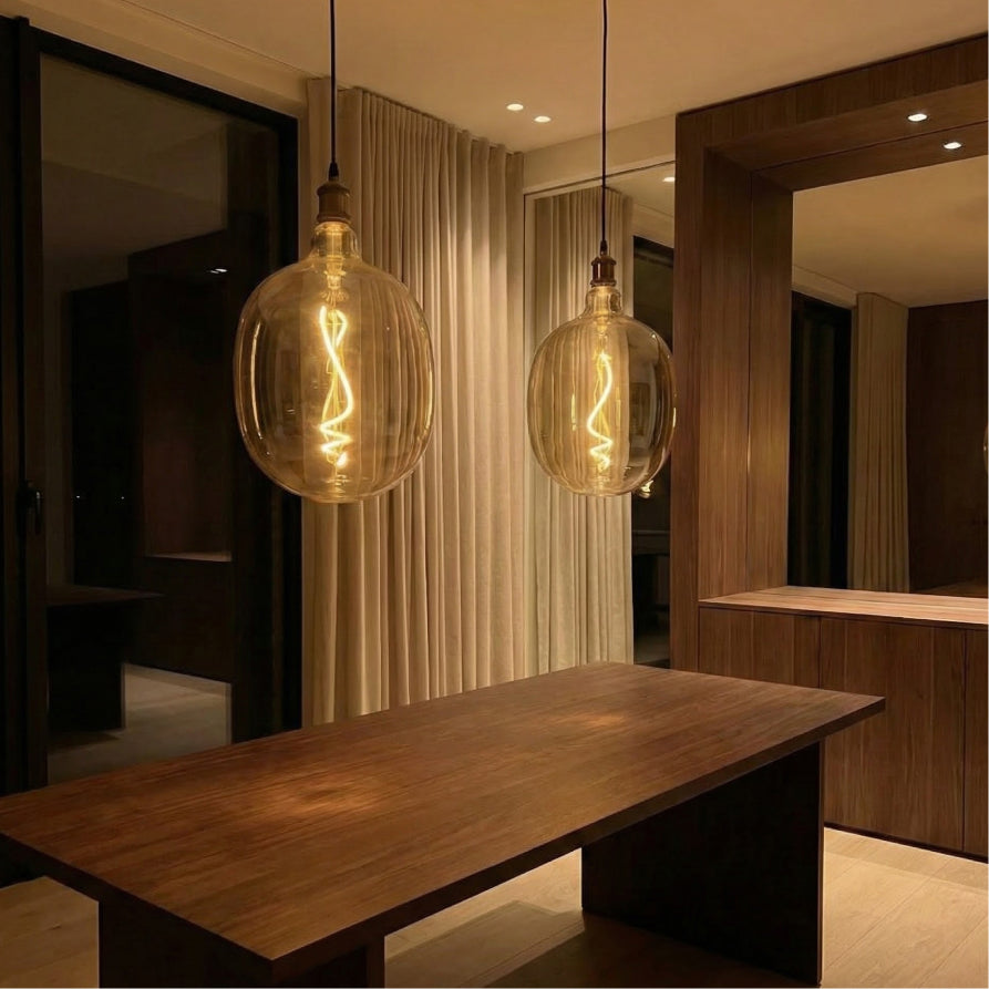 Modern interior with a wooden table and two hanging glass light fixtures.
