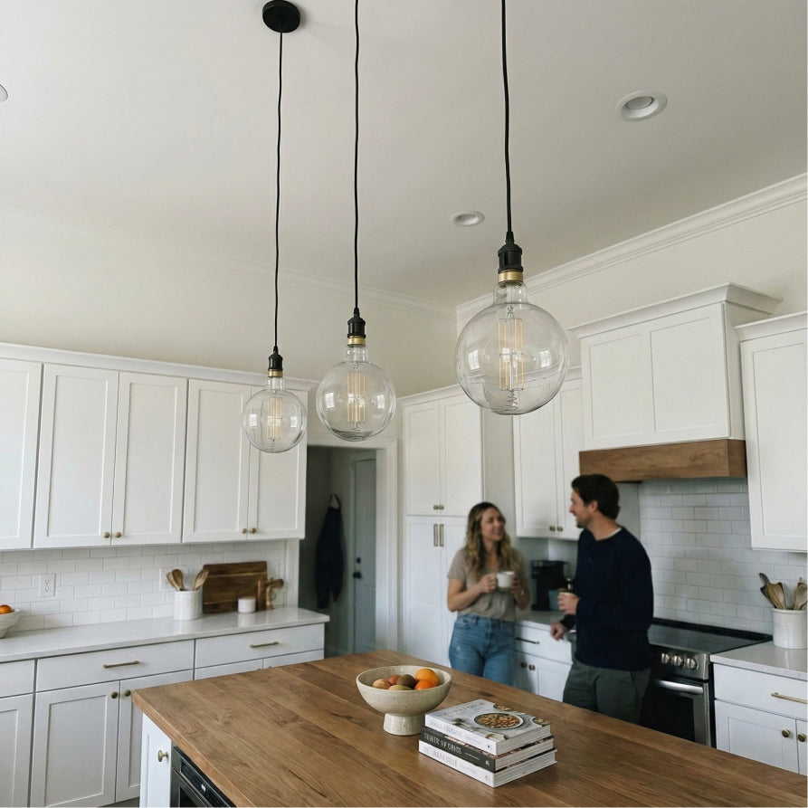 Modern kitchen with white cabinets, wooden countertops, and pendant lights.