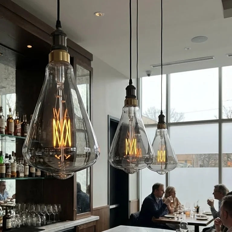 Modern restaurant interior with large decorative light bulbs and people dining.