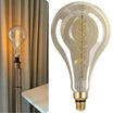 Vintage-style light bulb with decorative spiral filament next to a plain background