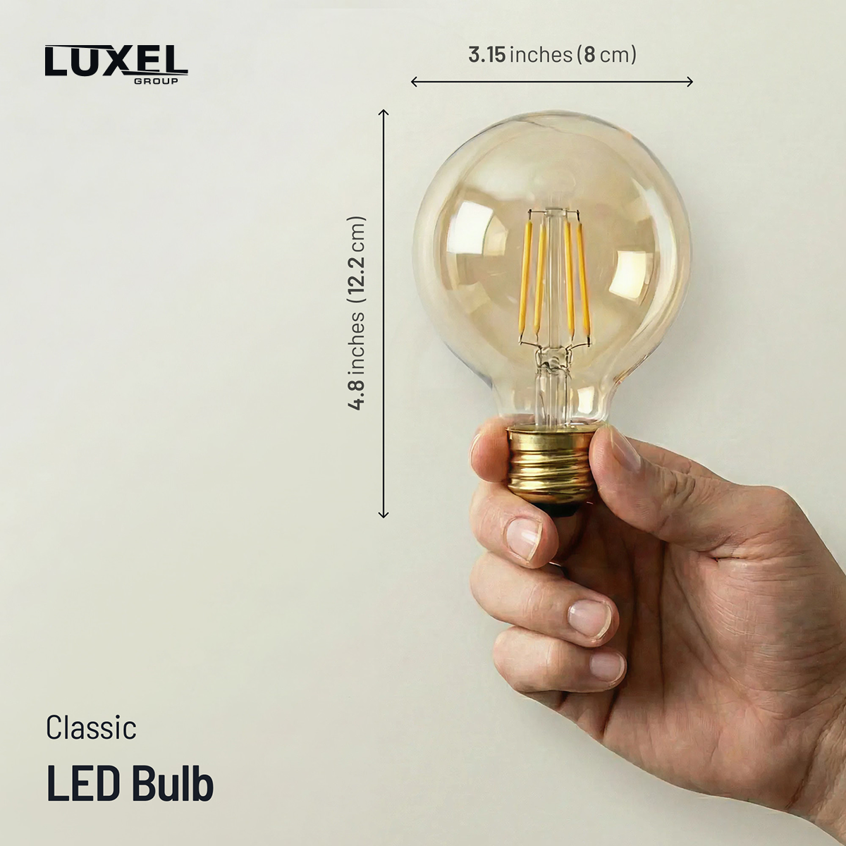 Hand holding a classic LED bulb with dimensions labeled, Luxel brand visible