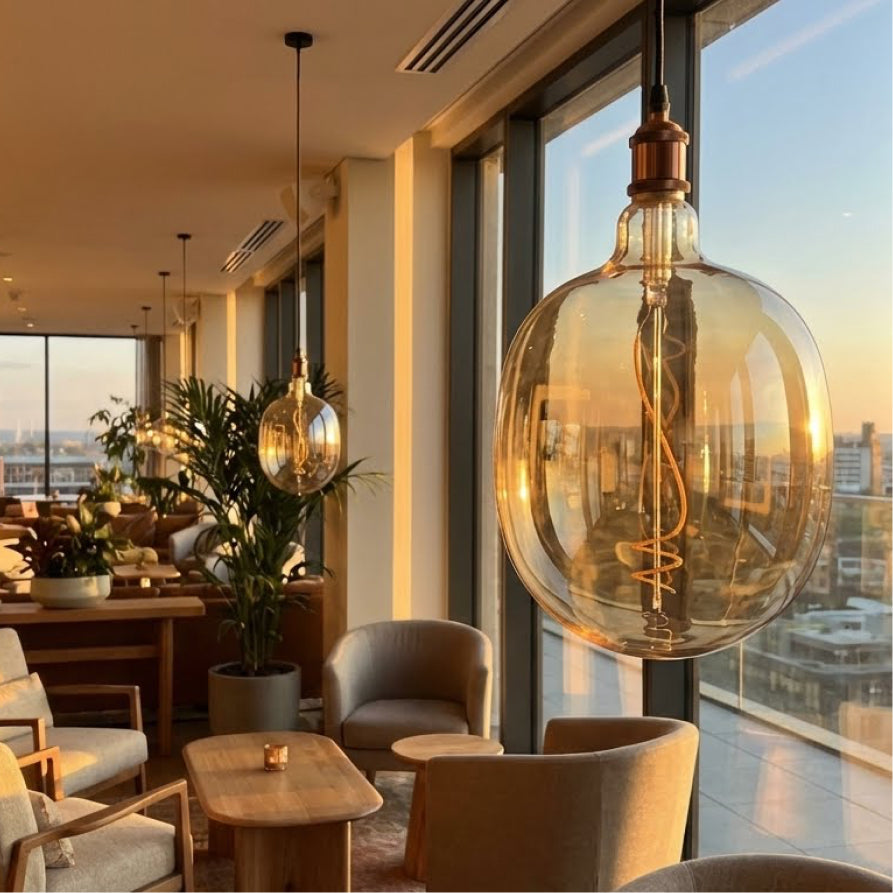 Modern interior with large glass pendant light, chairs, and a cityscape view.