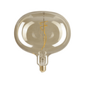 Close-up of oversized amber LED Edison bulb with spiral filament and reflective glass surface