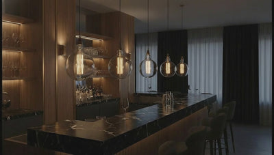 Vintage-style light bulbs hanging from the ceiling in a softly blurred room setting.